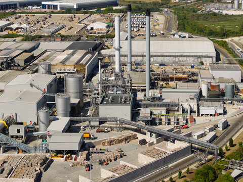 Sunny Paper Mill With Smokestacks and Storage Piles
