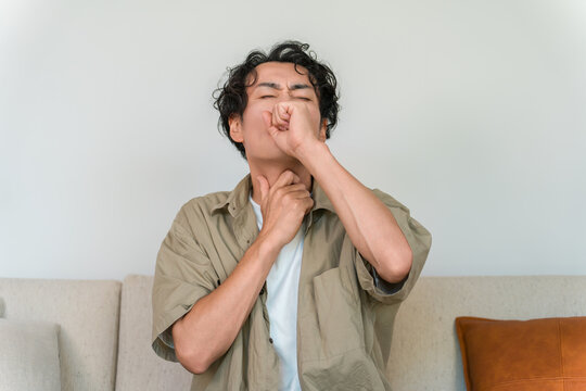 自宅で咳き込み喉の痛みに苦しむ中年男性（風邪,体調不良）