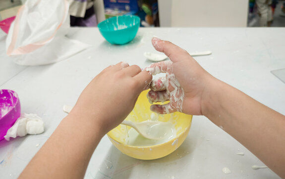 Child boy preparing non-Newtonian fluid with cornstarch