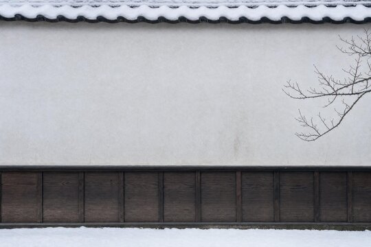 Snow beside a traditional Japanese plaster boundary wall