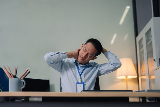 Male businessman is doing a stretchy posture due to sitting in the office for too long, office syndrome concept.