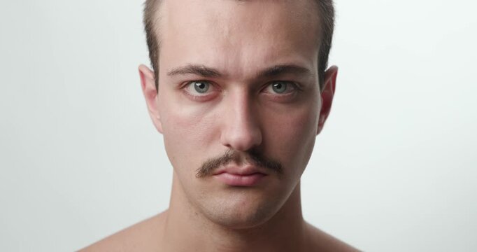 Studio Close-Up Portrait of Serious Angry Young Caucasian Man Staring at Camera