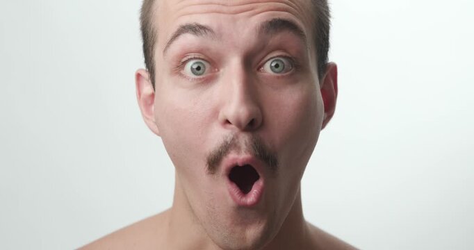 Studio Close-Up Portrait of Surprised Young Caucasian Man with Open Mouth