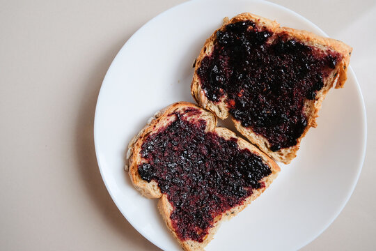 Golden toasted bread slices spread with rich dark berry jam