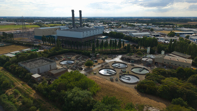 Aerial view of Spalding Power Station with tall chimneys and water treatment facility featuring circular sedimentation tanks in Spalding, England, United Kingdom.