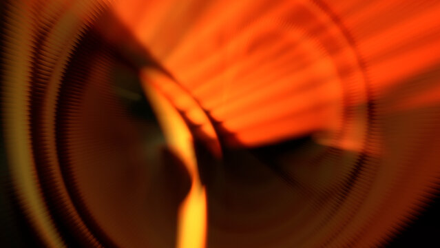 Fiery orange radial spin motion blur abstract background with dynamic glowing tunnel light rays effect
