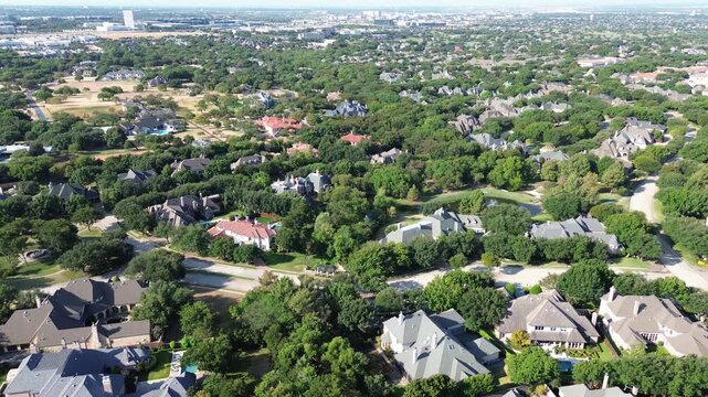 Panoramic forest canopies embrace custom Starwood residences near Stonebriar Country Club. Gabled architecture borders serene neighborhood waterways, emphasizing luxury living across Frisco, TX