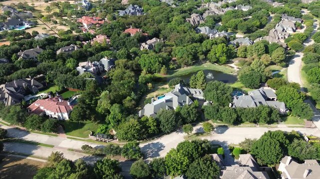 Curving asphalt lanes divide wooded Starwood properties near Stonebriar Creek. Vibrant red tile roofs contrast against dense green canopies, illustrating master planned elegance across Frisco, TX