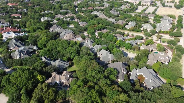 Dense green foliage envelops custom Starwood compounds near Legacy Drive. Varied gables meet secluded neighborhood cul de sacs, reflecting private residential elegance across Frisco, Texas