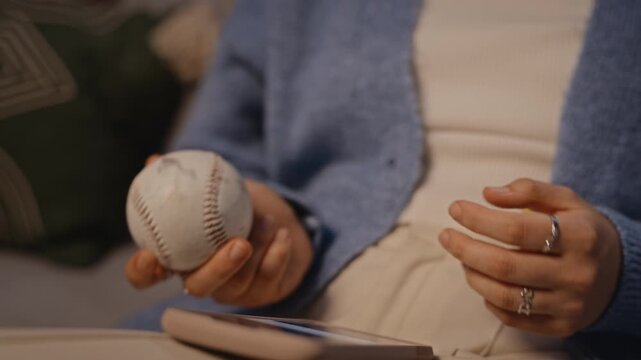 Young adult Caucasian woman scrolling on smartphone and fidgeting with baseball to relieve stress. Clip is perfect for marketing campaigns addressing digital burnout and mental wellbeing