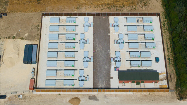 Aerial view of Bicker Fenn Battery Energy Storage Systems featuring rows of battery containers and electrical infrastructure within a fenced facility in Boston, England, United Kingdom.
