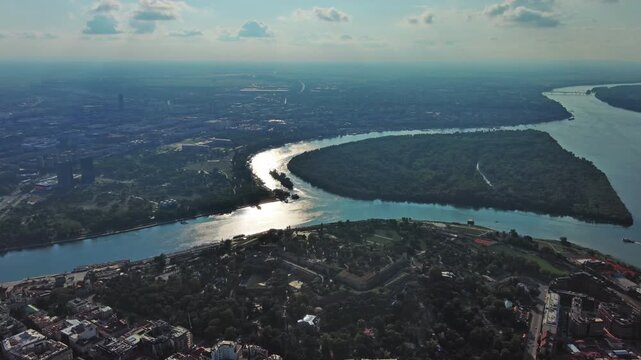 Aerial view of Belgrade at confluence of Sava and Danube rivers. Urban landscape, forested river island and city view, 4k