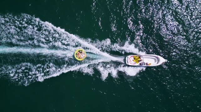 Aerial View of Speedboat Towing Inflatable Tube on Deep Blue Sea