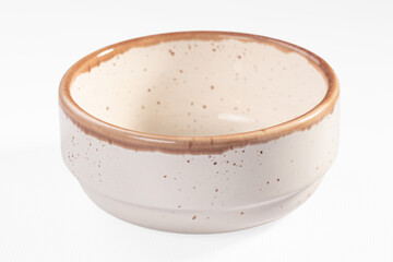 Ceramic bowl with speckled beige glaze and brown rim on white background
