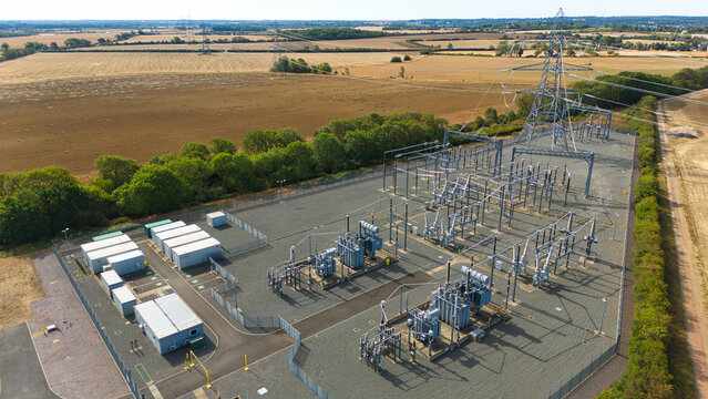 Aerial view of the National Grid Ryhall Substation 400kV featuring high-voltage transformers and electrical infrastructure amidst rural agricultural fields in Ryhall, England, United Kingdom.
