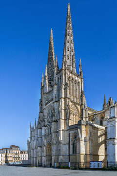 Gothic Bordeaux Cathedral facade viewed from the public square in Bordeaux, France. Bright daylight shows medieval stone