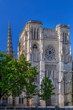 Gothic northern facade of Bordeaux Cathedral with tall spires in Bordeaux, France. Bright daylight highlights medieval stone