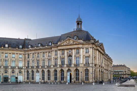 Classical facade of the right wing at Place de la Bourse in Bordeaux, France. Bright daylight highlights historic limestone