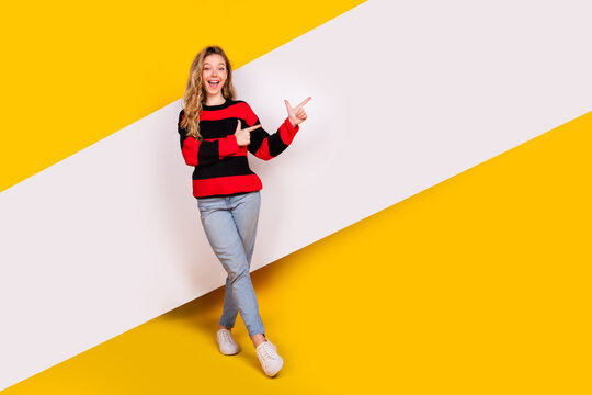 Cheerful young woman in a casual outfit striking a joyful pose against a vibrant yellow and white diagonal background