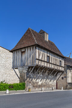 Medieval Eschif de Creyssac house perched on a narrow stone wall in Perigueux, France. Bright daylight view of historic timber