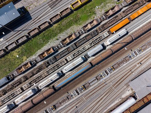 Aerial view of Chiasso Cargo Train Terminal with various freight train cars and cargo containers on parallel tracks in Chiasso, Ticino, Switzerland.