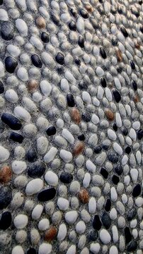 Natural pebble stone texture moving vertically for vertical video background overlay shot in 4K slow motion loop
