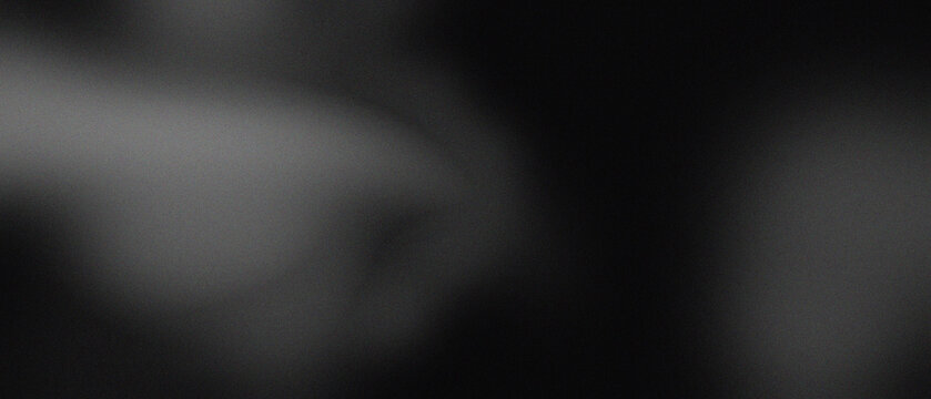 Abstract grainy black background with soft light diffusion with texture