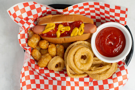 hot dog  with tater tots and onion rings