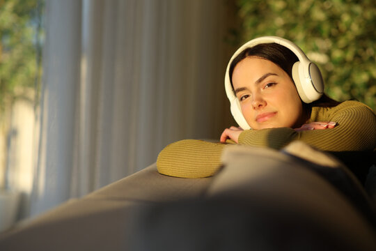 Confident teenager girl listening to music looks at you