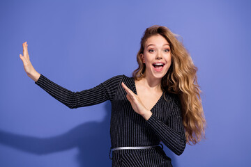 Joyful young woman in striped jumpsuit on blue background smiling and posing for fashion lifestyle...