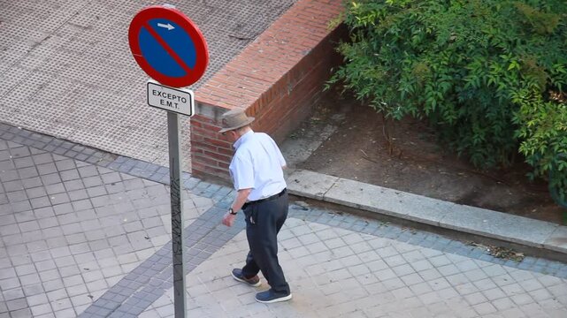 Paseo activo lento se&ntilde;or paseando mayor con bast&oacute;n camimando paseo tercera edad viejo paseando abuelo por acera de calle andando