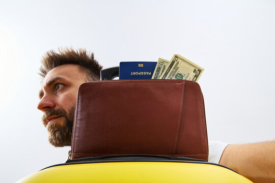 Surprised Male Tourist with Passport Money and Yellow Suitcase Ready for Travel