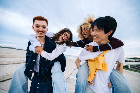 Friends sharing laughter on piggyback rides outdoors