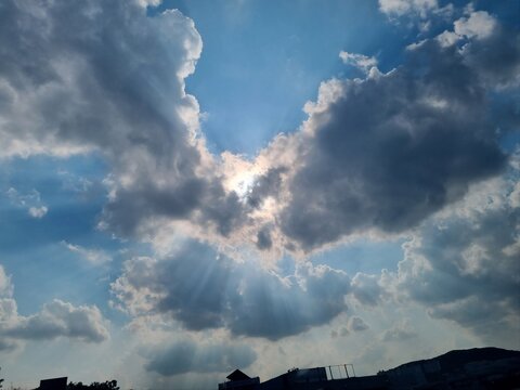 Sunlight breaking through dramatic clouds in blue sky