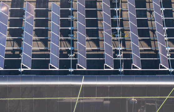 Aerial view of the Renewable Energy Technology Laboratory featuring rows of solar panels mounted on a dark roof in Gdansk, Pomeranian Voivodeshi, Poland.