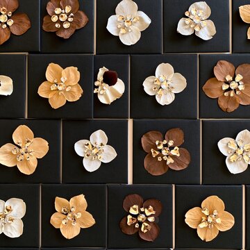 Grid of black mortarboards decorated with sparkling rhinestones and pressed petals, featuring a matte finish for graduation crafts and packaging design