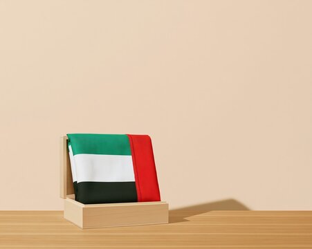 Folded UAE flag in a wooden box on a timber table, featuring soft textile textures and warm lighting with ample copy space for heritage layouts