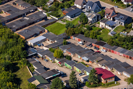 Aerial view of a residential neighborhood featuring rows of garages, private houses, and lush greenery in Kaunas, Kaunas County, Lithuania.