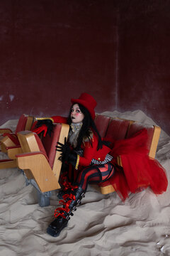Black gloved hand reaching out from performer seated in abandoned sand covered auditorium