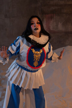 Close up of blue pierrot costume with ruffled collar and gold embroidered panel
