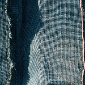 Wet woven polypropylene sandbag surface with damp textures and deep blue tones for flood defence and disaster risk reduction backgrounds