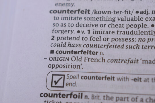 English Dictionary Book Page Close Up With The Word Definition Of - counterfeiter