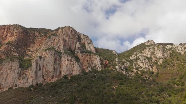 Towering Limestone Cliffs Rise Along The Southwestern Coast Near Porto Flavia In Masua, Sardinia, Italy. Aerial Shot