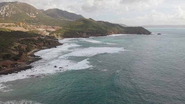 Rugged Coastal Cliffs Surround Pan di Zucchero Near Porto Flavia In Masua, Sardinia, Italy. Aerial Wide Shot