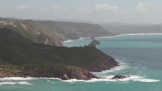 Sheer Limestone Cliffs Around Porto Flavia In Masua On The Southwest Coast Of Sardinia, Italy. Aerial Wide Shot