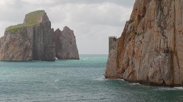 Porto Flavia Along The Coast Of Masua In Sardinia, Italy, Pan di Zucchero Sea Stack In The Background. Aerial Shot