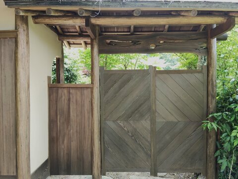 新緑の庭園に佇む趣ある和風の木造門