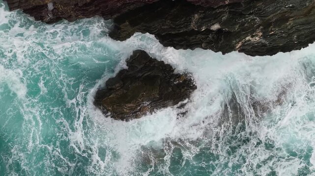 Foamy Rough Waves Hit The Rocky Coastline Near Porto Flavia In Masua, Sardinia, Italy. Aerial Topdown Shot