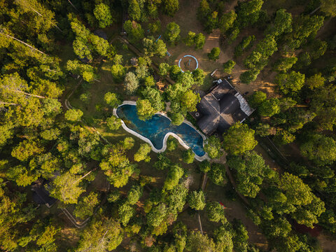 Aerial view of Spekta Merbabu featuring a swimming pool nestled within a dense forest with lush trees and a building in Getasan, Central Java, Indonesia.
