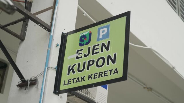 Close-up of a parking coupon sign in Malaysia, featuring multilingual parking information and payment guidance inside a modern urban car park, UHD